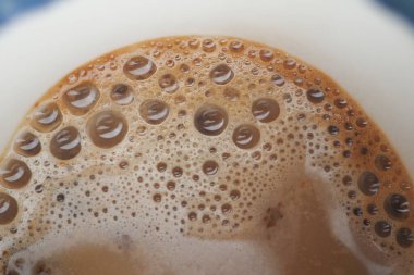 Köpük beyaz bir fincanda bir kahvenin üzerinde yükselir, keyif verir..