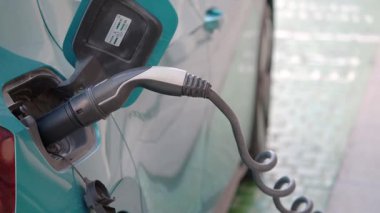 Şehirdeki bir şarj istasyonunda elektrikli bir araca şarj oluyor..