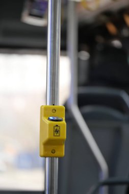 Bir belediye otobüsünün içindeki sarı stop istek düğmesinin yakın plan görüntüsü.