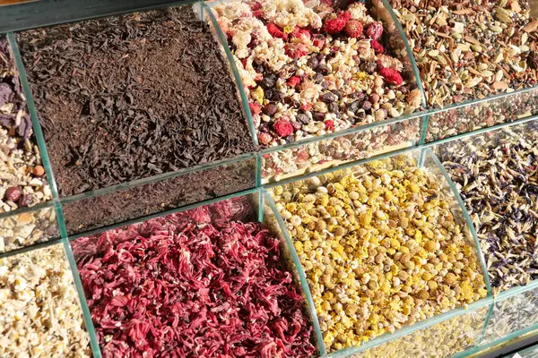 Bir markette konteynırlara yerleştirilmiş çeşitli kurutulmuş otlar, baharatlar ve çiçekler..