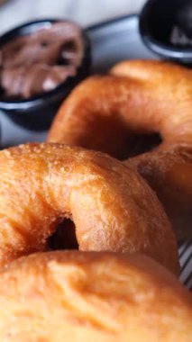 Sıcak, altın çörekler bir kase çikolata sosunun yanında..