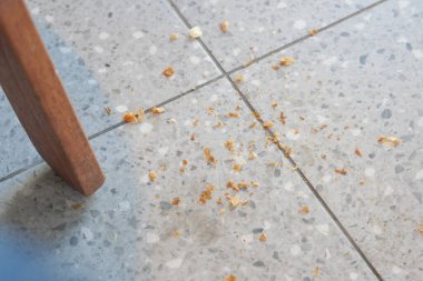 Küçük kırıntılar, iyi aydınlatılmış bir yerde sandalyenin altına yayılır..