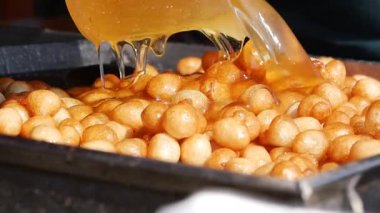 Kalabalık sıcak yağda kızartılmış atıştırmalıkların tadını çıkarmak için toplanıyor..