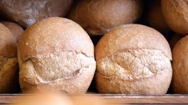 Tam tahıllı somun ekmeği ahşap bir rafta, dokuyu gösteriyor..