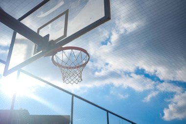 Oyuncular güneşli öğleden sonra ışığında güneşlenirken basketbol oynamayı severler..