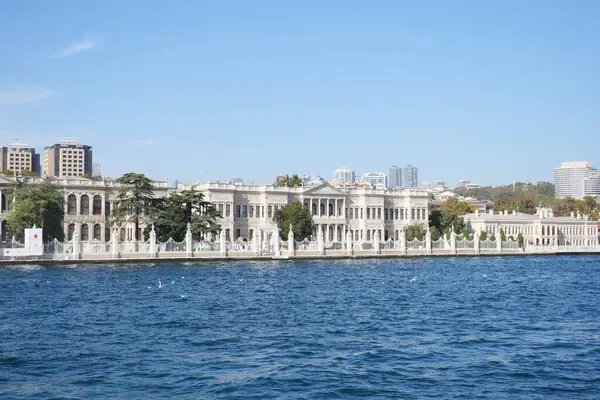 Güzel mimari açık mavi gökyüzünün altında nehir kıyısında duruyor..