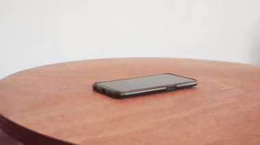 Tahtanın üzerinde duran akıllı telefonu elle seç..