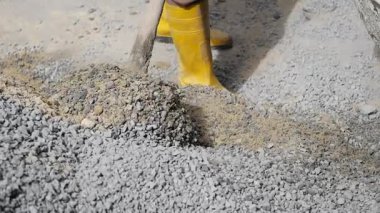 İnşaat işçisi bölgede çakıl düzenlemek için kürek kullanıyor..