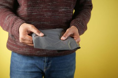 Bireyler kapalı alanda gri paketleri dikkatle taşıyorlar..