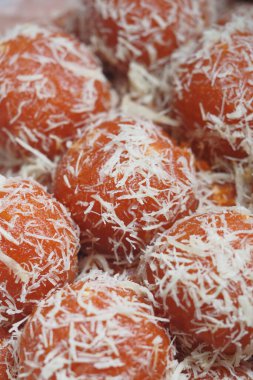 Parçalanmış hindistan ceviziyle kaplanmış renkli yuvarlak tatlılar dikkat çeker..