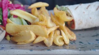 Lokantalar canlı bir lokantada lezzetli bir dürüm ve kızarmış patatesin tadını çıkarırlar..