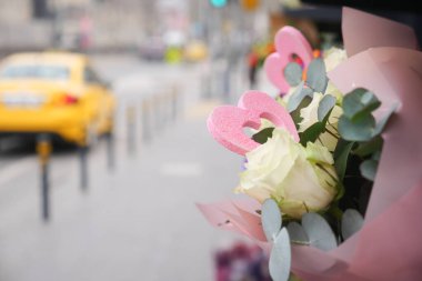 Kalp şekilli renkli çiçekler kaldırımda sergilenir..