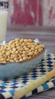 Sarı soya fasulyesi bir kasede desenli bir kumaş üzerinde sergilenir, yemekler için mükemmeldir..