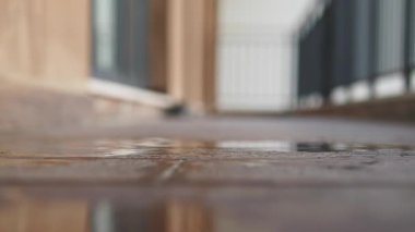 Islak zemin, koridordaki ışığı yansıtan bir su birikintisi gösteriyor..