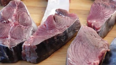 Taze kesilmiş balıklar pazardaki tahta bir tahtanın üzerinde sergilenir..