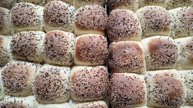 Susam tohumlarıyla kaplı yumuşak ekmek ruloları güzelce satılığa çıkarılır..