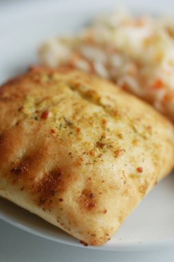 Taze lahana salatasının yanında servis edilen çıtır çıtır bir dokuma ile lezzetli pişmiş öğe..