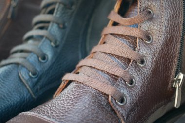 Mağazada bağcıkları bağlı kahverengi ve siyah deri ayakkabıların yakın görüntüsü.