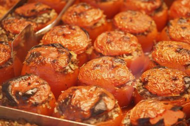 Doldurulmuş domatesler hareketli bir markette sıcak bir şekilde sergilenir..