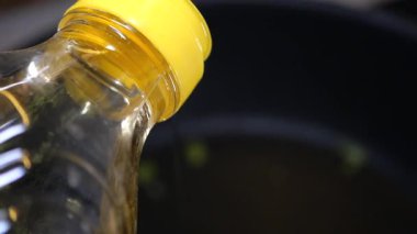 Temiz yağ bir tavaya ekleniyor, yemek malzemelerine hazırlanıyor..