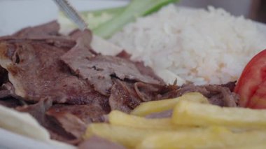 Yumuşak pirinç ve taze sebzelerle servis edilen tuzlu ızgara et..