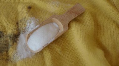 Sarı kumaştaki kabartma tozuyla lekeleri çıkarmak için ipuçları.