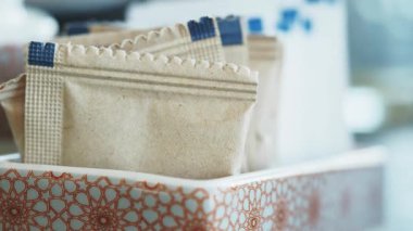 Şeker paketleri bir kafede şık bir konteynırda güzelce düzenlenir..