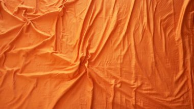 Turuncu kumaş seriliyor, çeşitli yaratıcı projeler için ideal..