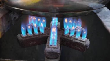 Mutfakta yemek pişirilirken gaz ocağından mavi alevler püskürüyor..