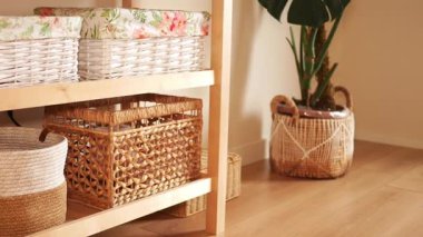 Örülmüş depolama sepetleri, sakin bir yaşam alanındaki kapalı bitkileri tamamlar..