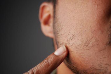 Bir el nazikçe yanağındaki sakala dokunuyor, kişisel tımarı vurguluyor..