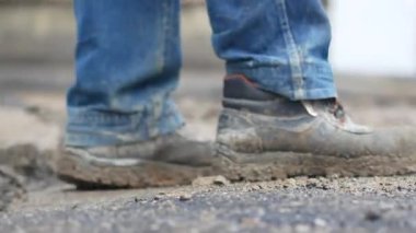 Şehir merkezinde bot giyen inşaat işçileri ekipmanla ilgileniyorlar..