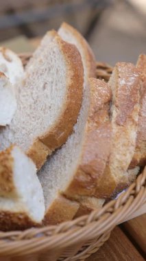 Yumuşak, kabuklu ekmek dilimleri dokuma sepetinde, paylaşmak için ideal..
