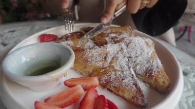 Bir insan pudra, çilek ve şurupla süslenmiş tatlı bir yemekten hoşlanır..