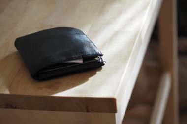 Cüzdanı ahşap bir masada sıcak, doğal ışık altında, cüzdan konsepti kayıp. .