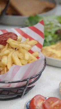 Canlı bir ortamda taze sebzelerin yanında lezzetli patates kızartmalarının tadını çıkarın..