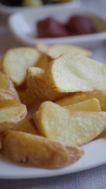 Sıcak servis edilen altın patates dilimlerinin tadını çıkarın..