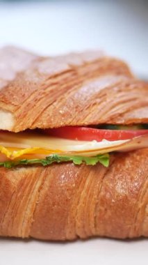 Taze sebze, peynir ve hindi ile dolu lezzetli bir kruvasanın tadını çıkarın..