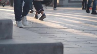 Yayalar hareketli bir şehir bölgesinde güneşli bir geçitte yol alırlar..