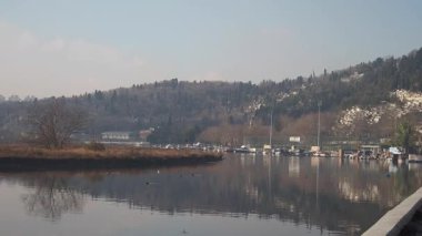 Sakin sular, sakin nehirde yüzen kayıklar gibi tepeleri yansıtır..