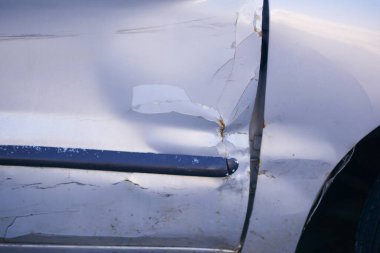 Arabanın yan tarafında belirgin çizikler ve kapıda bir çentik var..