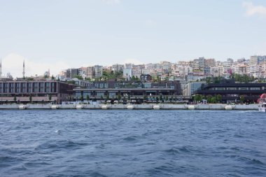 Binalar ve su aktiviteleriyle dolu canlı bir rıhtım manzarası