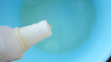 Temizlik görevleri için mavi bir kaseye sıvı ekleniyor.