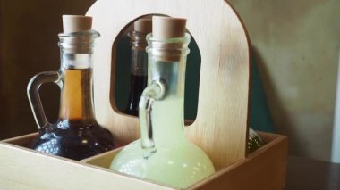 İçeceklerle dolu iki cam şişe şık bir şekilde ahşap bir tutacağa konur..