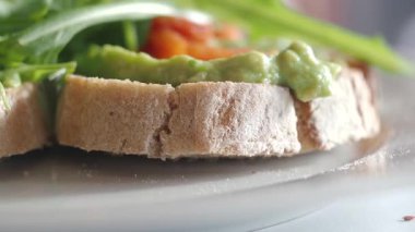 Yeşillikli ve taze servis edilen avokado tostunun yakın çekiminin tadını çıkarın..