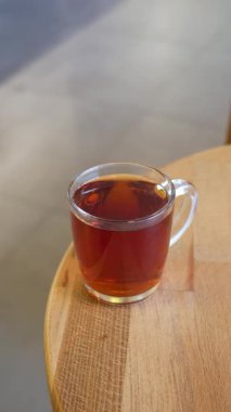 Lezzetli bitkisel içecek, rahat ahşap bir yüzey üzerindeki temiz bir bardağı doldurur..