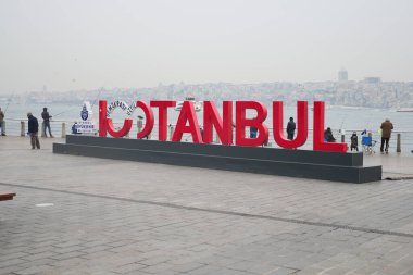 Ziyaretçiler İstanbul 'u su kenarında heceleyen büyük kırmızı harflere hayran.