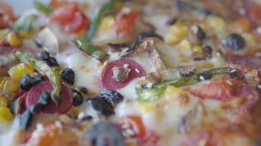 Sebze ve etle kaplı lezzetli bir pizzanın tadını çıkarın..