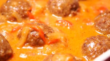 Baharatlı köfteler aromalı bir sosta otlar ve sebzelerle kaynıyor..