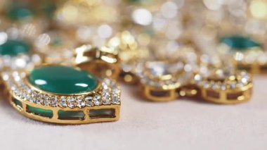 Karmaşık mücevherlerde zarif altından yapılmış muhteşem zümrüt taşlar bulunur..